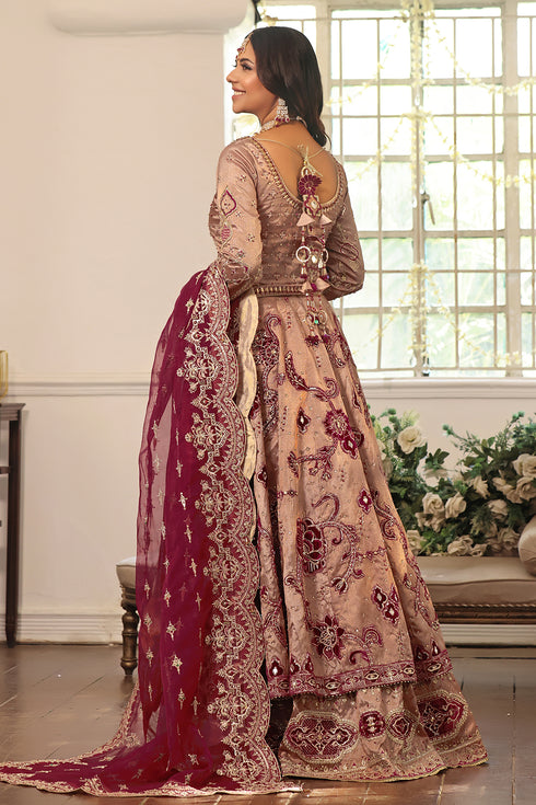 Side shot of Naqshi Anamta highlighting fitted sleeves, round neckline, heavy choli embroidery, and double‑layer lehenga with velvet appliqué.