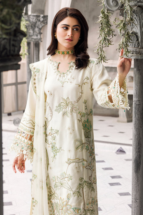 Mid shot highlighting front shirt embroidery and straight trouser styling