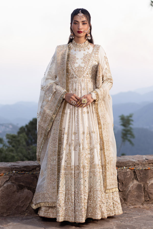 Naqshi Fasana dove‑white floor‑length raw‑silk frock with halter neckline, deep back, heavy hand‑adda—kora, dabka, sitari, tilla, crystal embellishments—and structured pouch.