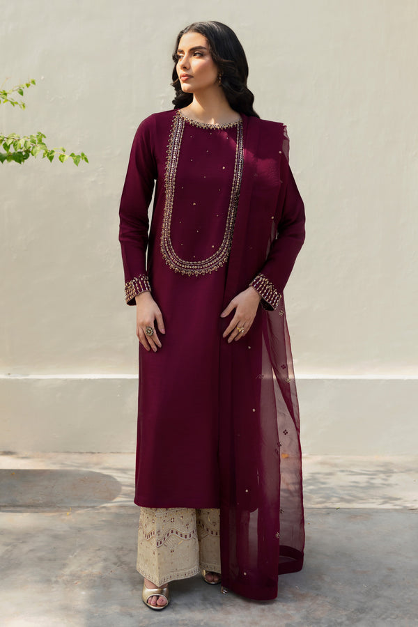 Stylized ensemble
Model wearing full NAQSHI Parize set: burgundy hand‑adda shirt, skin culottes with sequin detailing and crystal‑tassel organza dupatta for a refined festive look.