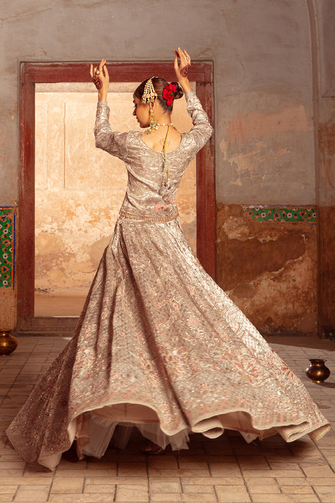 Model styled in full Naqshi Raniya 4PC ensemble: copper-peach choli, lehenga, embroidered pouch & dupatta styled for regal wedding elegance.