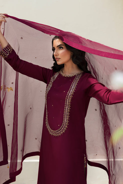 Close‑up of NAQSHI Parize shirt neckline and upper sleeve featuring ornate hand‑adda work combining kora, dabka, stone, cut dana and crystal embroidery on burgundy raw‑silk.