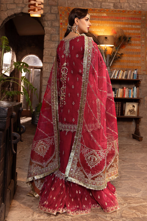 Side shot of naqshi nehal showing detailed side-panel embroidery, contrast orange-gold goti border, lace trims, and volume of gypsy sharara silhouette.