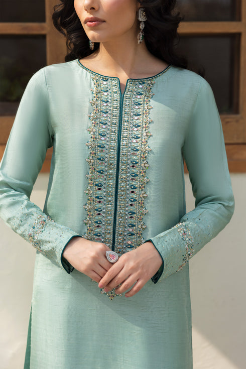NAQSHI Tania showing fluid straight shirt, contrast teal piping along sleeves, and peek of embroidered culottes below.