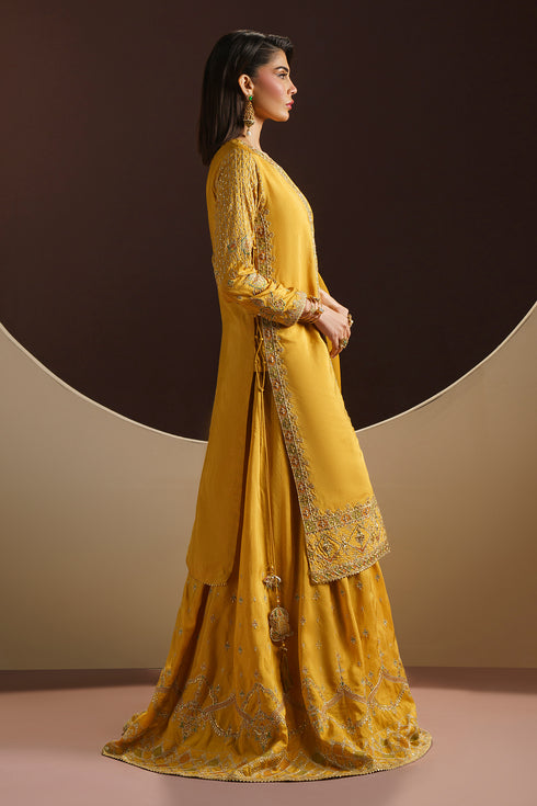 Walking pose of MAYA festive dress displaying embroidered sharara flare and lace borders