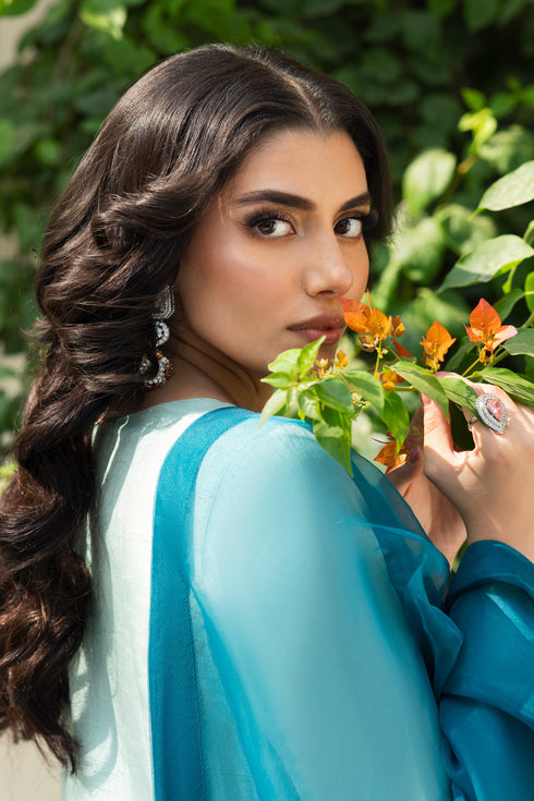 Detailed shot of NAQSHI Tania shirt sleeve showing intricate adda work—kora, dabka, cut dana, pastel stones and mirror embellishments on aqua fabric.