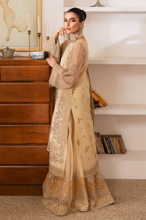 Model wearing NAQSHI Marve seated, highlighting shirt’s embroidered neckline, crystal tassels, star motifs, contrasted by sharara and draped dupatta.