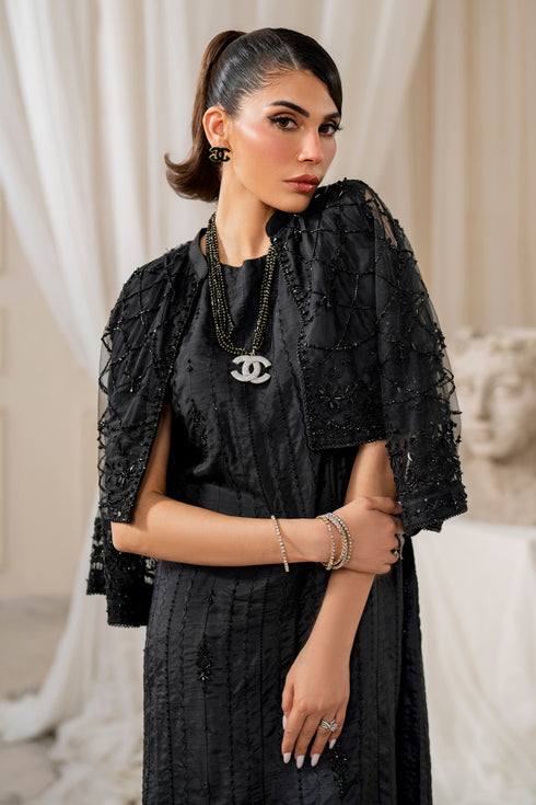 Macro shot of naqshi siara shirt front showcasing delicate sequin embroidery on black raw silk with geometric motifs.