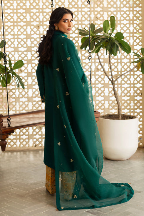 Model wearing full NAQSHI Zauq 3PC set: teal-green hand-adda shirt, mustard culottes, organza dupatta—complete festive-ready look.