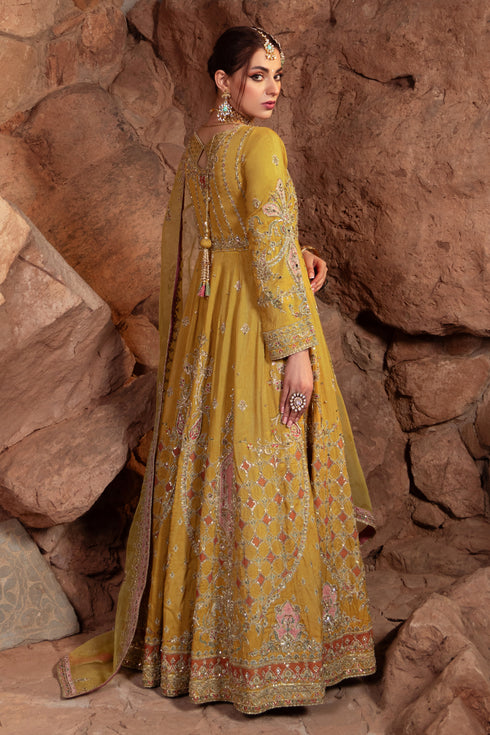 Side view of Naqshi Adeen showing frock panel embroidery in blush‑pink raw‑silk applique, orange & pista hues, fluid silhouette, and potli accessory detailing.