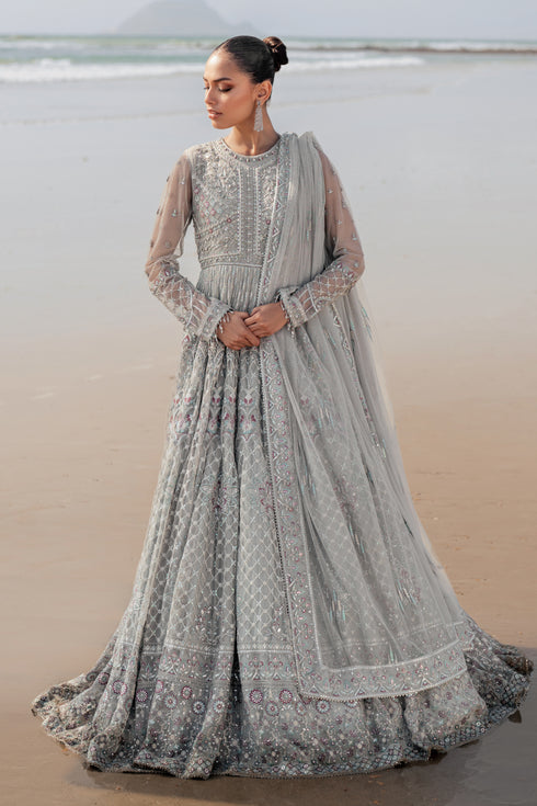 NAQSHI Valeria silver net maxi frock with floor‑length cutline, near‑neck neckline, heavily hand‑adda embellished bodice and sleeves, dense sequin embroidery and contrasting lace‑trimmed floral motifs.