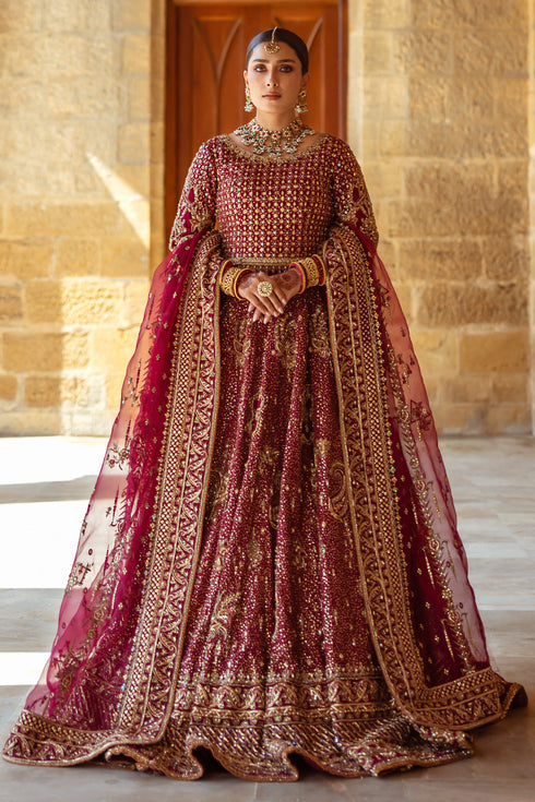 NAQSHI Kandhari plum raw‑silk bridal lehenga choli with round neckline, scalloped three‑quarter sleeves, heavily embellished with hand‑adda—naqshi, dabka, payal, sitari, cut dana, crystal hangings—paired with potli clutch.