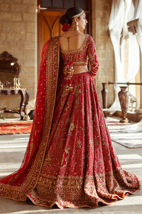Side profile of NAQSHI Shahana showing voluminous lehenga flare, texture-play on panels, scalloped sleeve detailing, crystal hangings and structured dupatta drape.