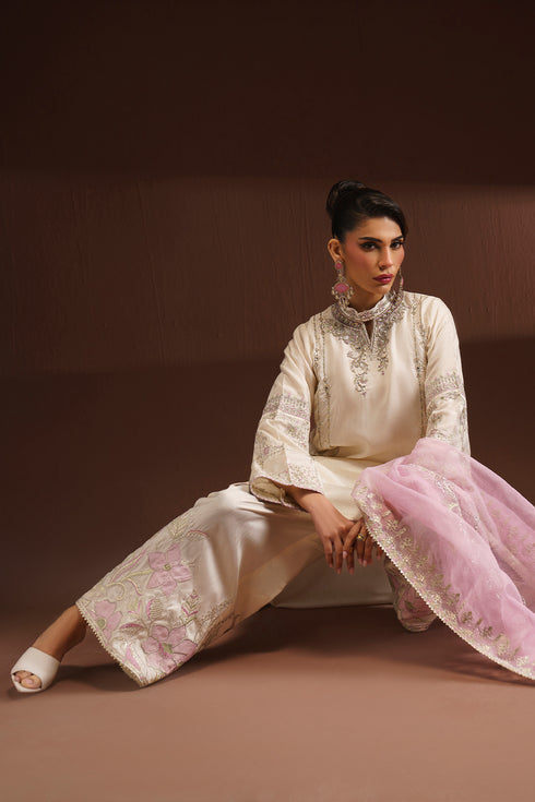 Seated pose of NAQSHI AMSAH formal outfit showing culotte pants embroidery and organza dupatta border