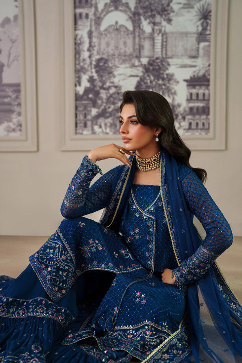 Nia by NAQSHI angled view showcasing the deep cut neckline, textured sequin embroidery, and flowing silhouette