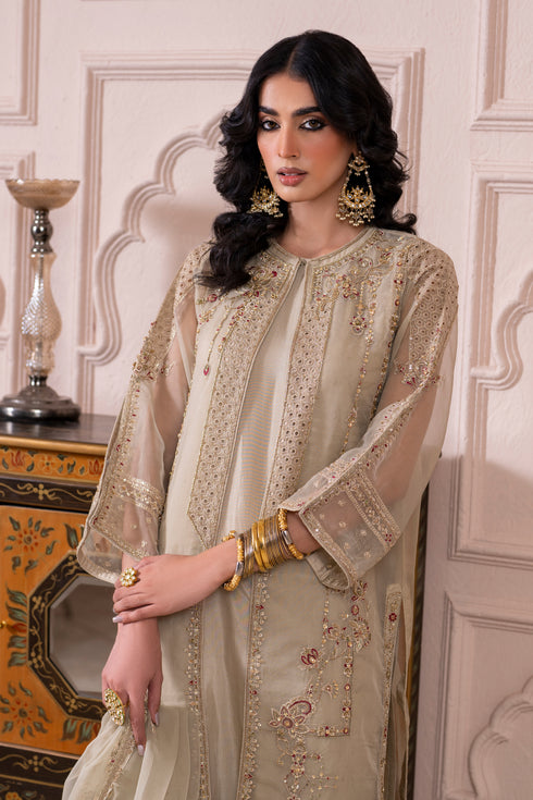 Close‑up of Naqshi Arwa gown hem adorned with embroidered boring patterns and decorative sitari accents.