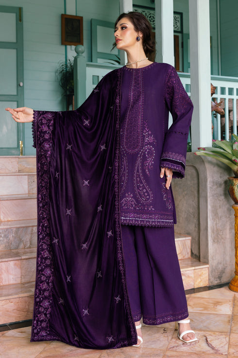 Woman wearing a purple traditional outfit with intricate designs in an indoor setting.