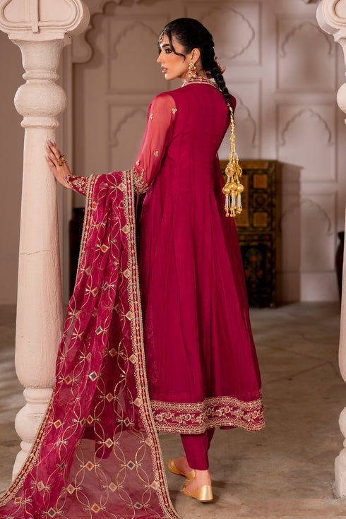 Side view of Zaafia showcasing flowing paneled frock silhouette, embellished extended sleeves with floral motifs, and contrast orange‑zinc embroidery accents.