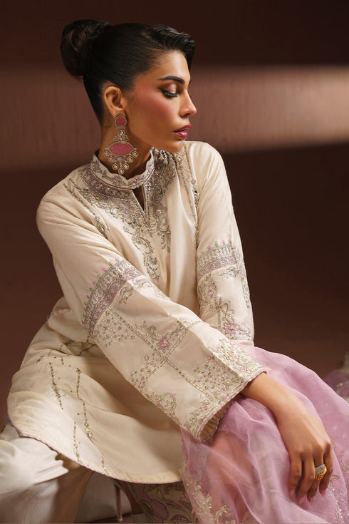 Side seated view of NAQSHI AMSAH ready to wear dress showing sleeve embroidery and dupatta fall