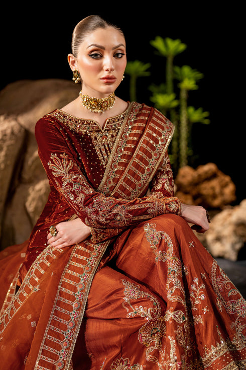 Side seated view of NAQSHI Amber formal outfit showing velvet shirt texture and embroidered organza dupatta