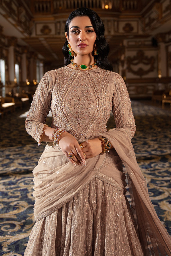 Model wearing full Naqshi Areeza bridal set: skin‑gold embellished choli, voluminous lehanga & ornate dupatta styled for bridal grace.