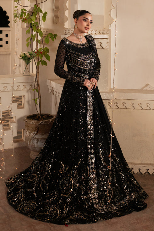 Woman in a black sequined gown standing in an ornate room.