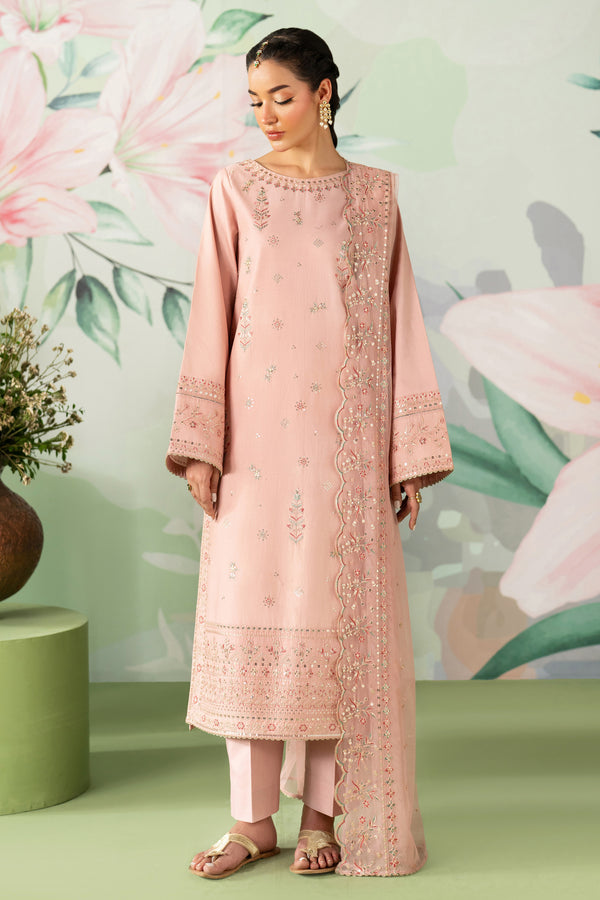 Woman wearing a pink embroidered outfit with a floral background