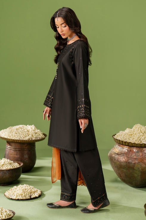 Side standing view of NAQSHI Isma outfit highlighting clean shirt cut and embroidered cambric shalwar