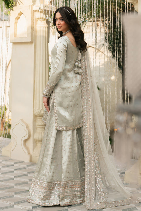 Back view of Meelina silver tissue shirt with wide flare sharara and net dupatta, elegant formal evening outfit