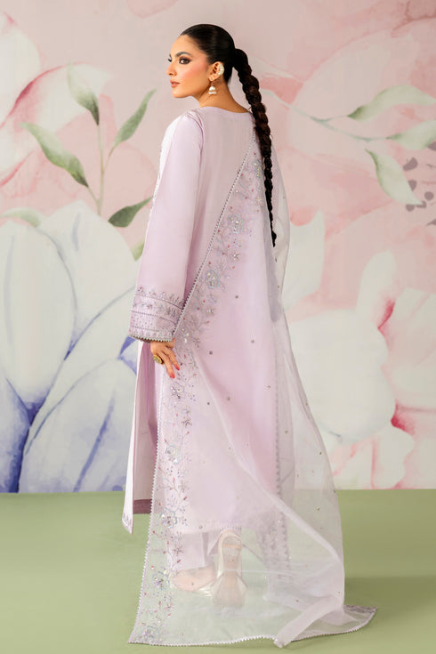 Woman in a light pink traditional outfit with a floral background