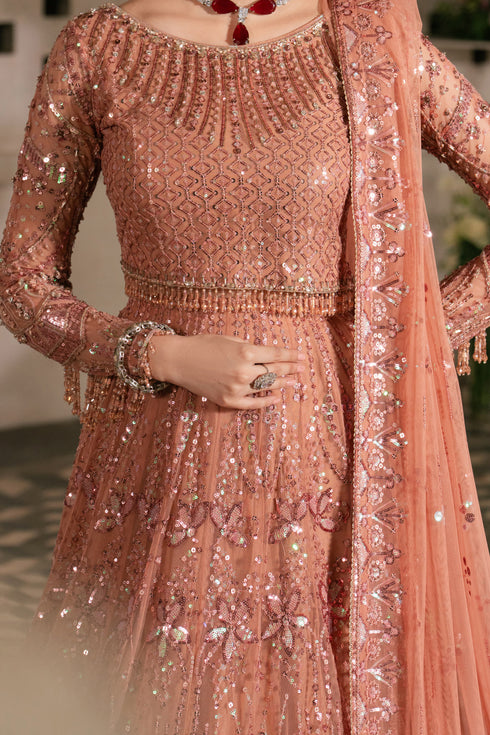 Peach-colored embroidered traditional outfit with intricate patterns.