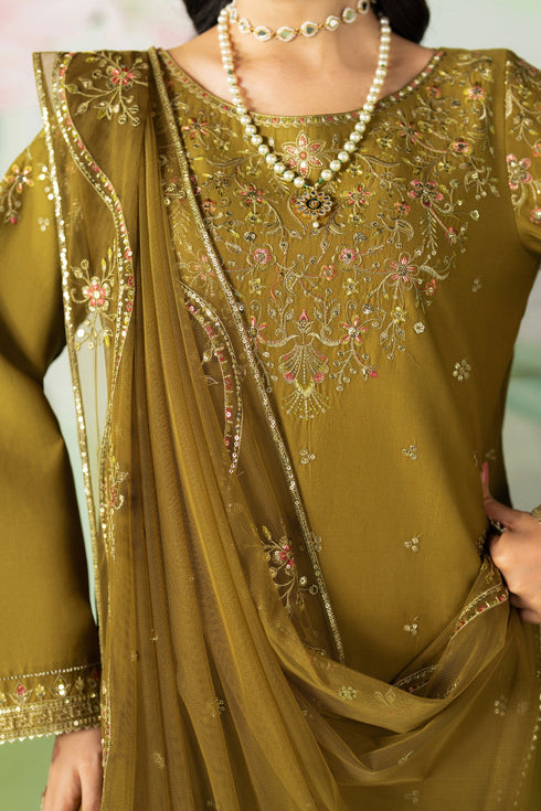 Close-up of a person wearing a green embroidered outfit with a necklace.