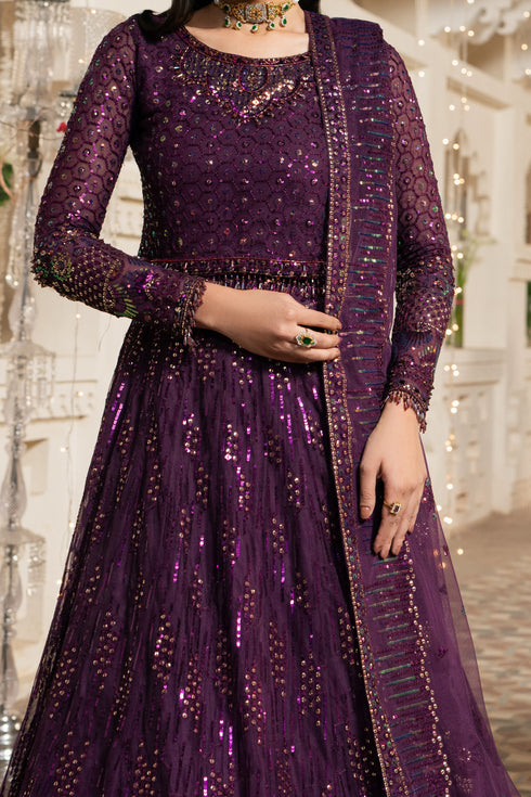 Purple embroidered traditional outfit with a matching dupatta against a decorative background