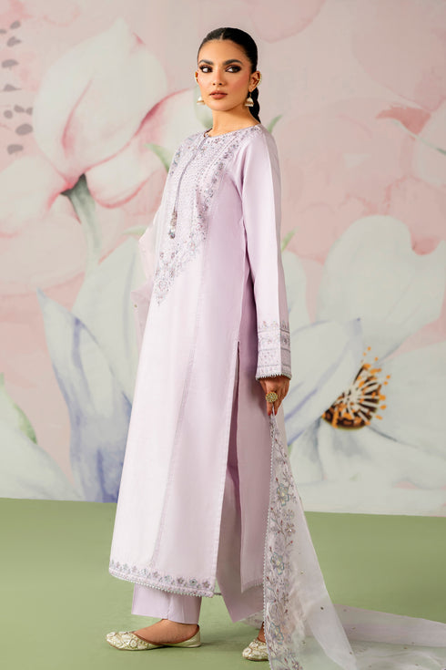 Woman wearing a light purple traditional outfit with floral embroidery against a floral background