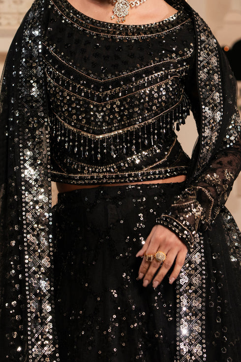 Black sequined outfit with intricate detailing on a neutral background