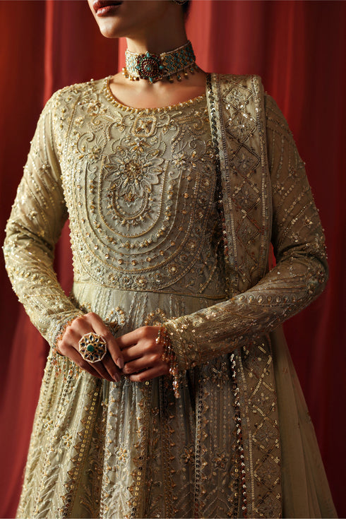 Model wearing NAQSHI Karishma 3-piece pistachio ensemble with embroidered frock, matching trousers and net dupatta