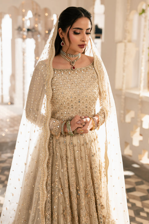 Woman in a traditional embroidered outfit with a veil in an elegant interior setting.