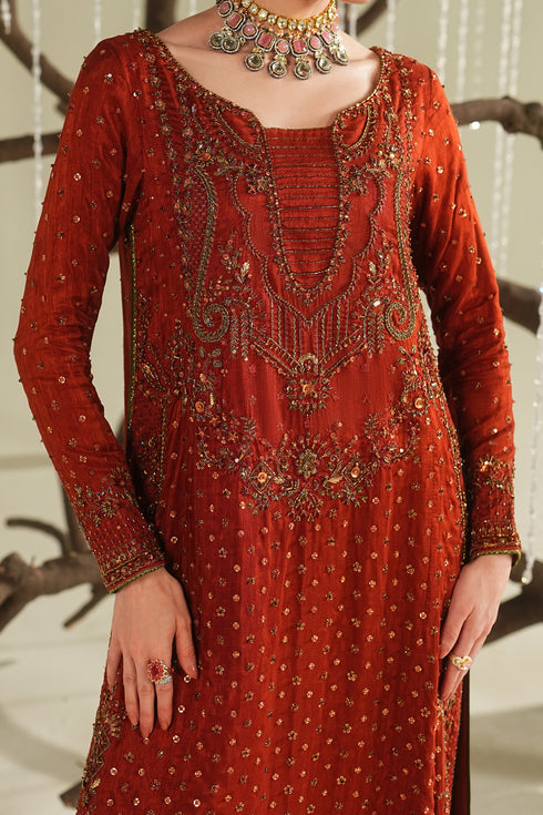 Close-up of rust orange formal shirt showing detailed embroidery, neckline design, and fine fabric texture