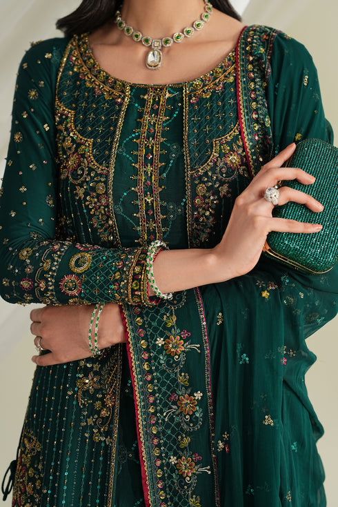 Close-up of bottle green formal gown showing detailed embroidery, neckline design, and sleeve border work.