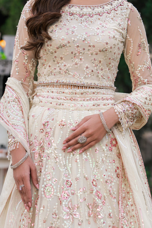 Beige embroidered traditional outfit with floral patterns.
