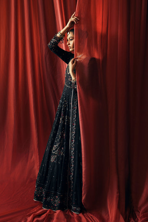 Side profile of NAQSHI Mah Afroz black gown showing flowy panels, angled sleeves, and sequin embroidery detail