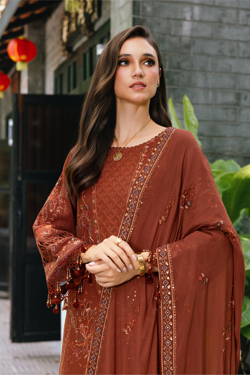 Woman wearing a brown embroidered outfit with a blurred background