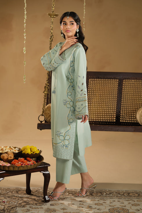 Side pose of Kiswa aqua festive dress showing modest shirt length and straight comfortable trousers