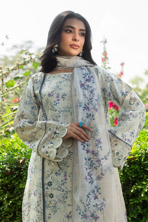 Side angle of Jaizah off white lawn dress highlighting floral print, lace sleeve borders and delicate cutwork hem detail
