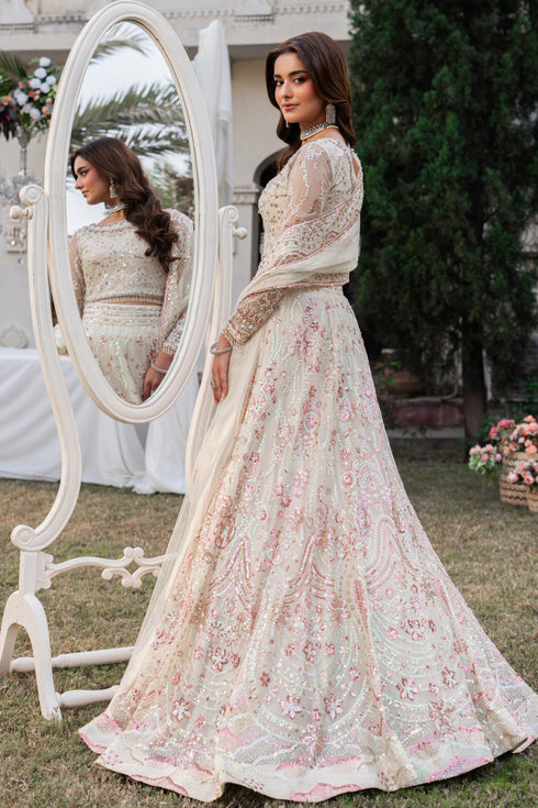 Woman in a floral dress standing next to a mirror outdoors.
