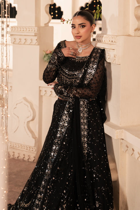 Woman wearing a black sequin dress in an elegant interior setting