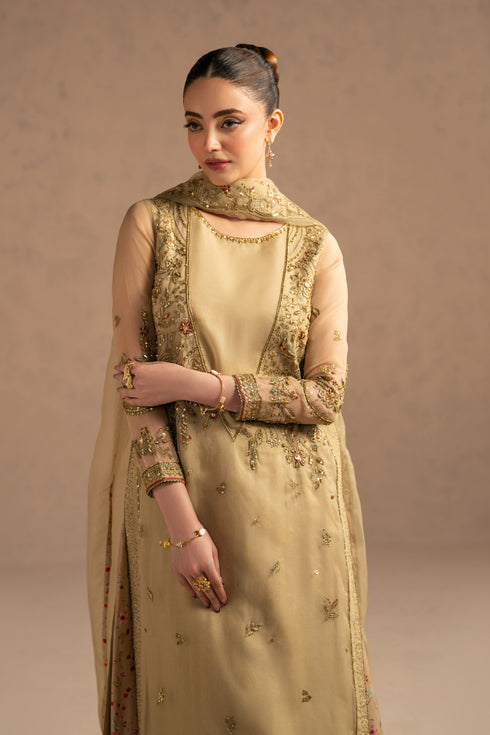 Close portrait focusing on neckline embroidery, sleeve borders and delicate sequin work on soft neutral fabric.