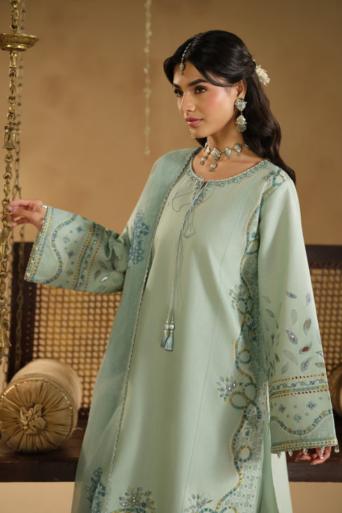 Close up of Kiswa shirt embroidery, adda work neckline and cutwork border detailing on aqua Pima lawn fabric