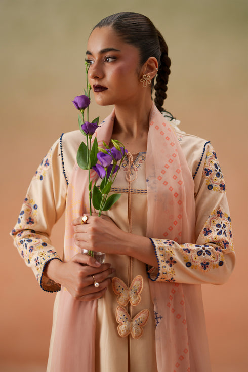 Close-up of Faye light peach embroidered neckline, tassel detail, quarter sleeves, and printed crinkle chiffon dupatta.