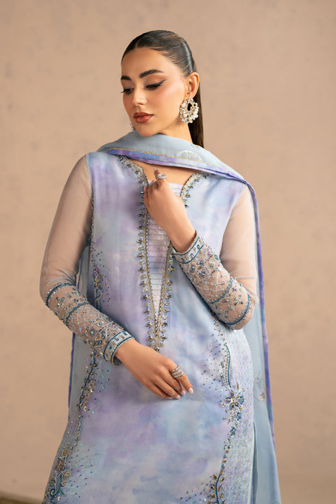 Close portrait highlighting neckline embellishment and sky blue shade, polished occasion ready stitched suit.